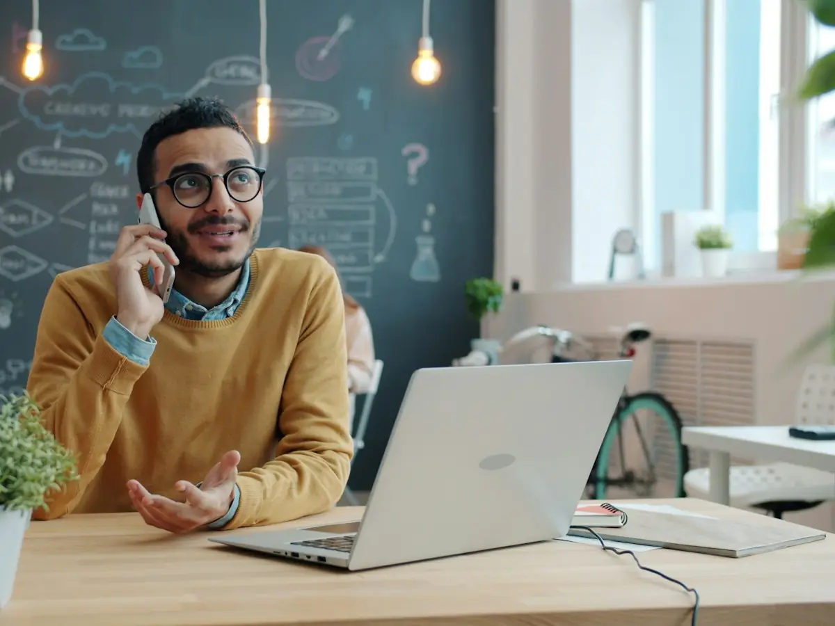 Handlowiec rozmawia z klientem przez telefon przy laptopie