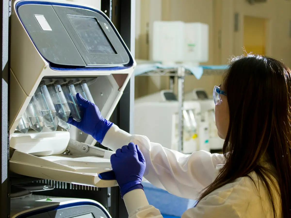 Laborantka umieszcza próbki w aparaturze laboratoryjnej